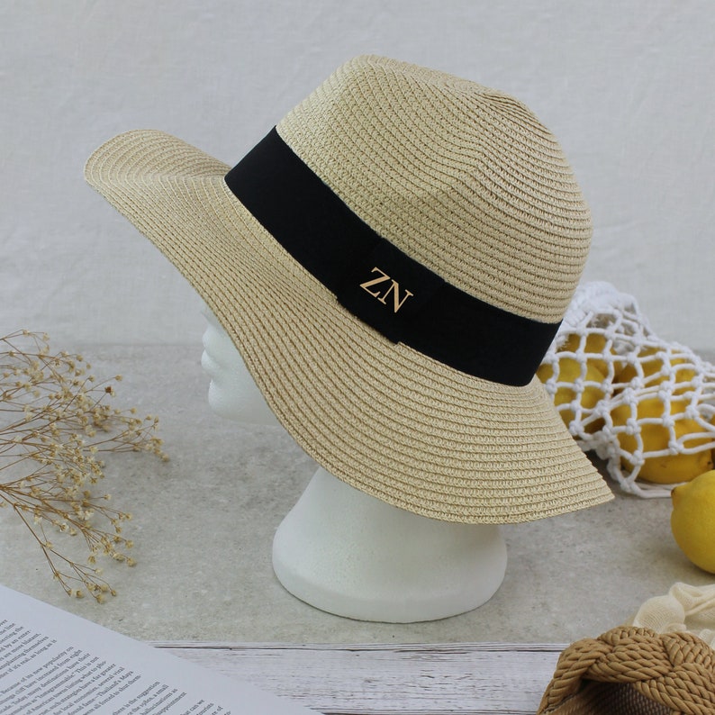 Peut inclure: Un chapeau de paille &agrave; larges bords avec un ruban noir et les initiales "ZN" en lettres dor&eacute;es.