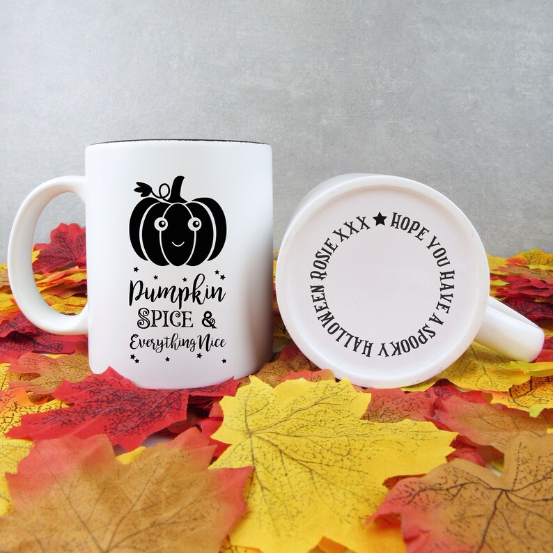 May include: White ceramic mug with a black rim and handle, featuring a black pumpkin graphic and the text "Pumpkin Spice & Everything Nice." The bottom of the mug has the text "Halloween Rosie XXX Hope You Have A Spooky".