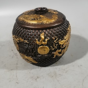 Op de afbeelding: Een bronzen, ronde container met een deksel. De container heeft een geweven textuur en is versierd met goudkleurige drakenmotieven. Het deksel heeft een kleine handgreep en een drakenontwerp. De tekst "PerfectChina" is onderaan zichtbaar.