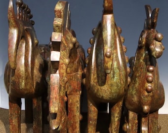May include: Four bronze horse sculptures with a green patina finish. The horses are standing in a row, facing forward. The sculptures are detailed with textured surfaces and small, round accents.