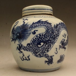 Könnte beinhalten: Eine weiße Porzellanvase mit einem blauen und weißen Drachenmuster. Die Vase hat einen Deckel und ist mit einem traditionellen chinesischen Muster verziert.