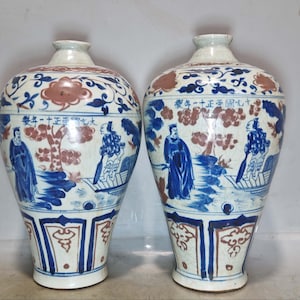 Un par de raros y exquisitos jarrones antiguos chinos pintados a mano con figuras rojas bajo cubierta en azul y blanco.