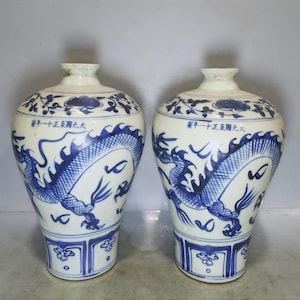 Un par de raros y exquisitos jarrones antiguos chinos pintados a mano con patrón de dragón rojo bajo cubierta en azul y blanco.