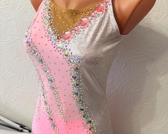 May include: Pink and silver leotard with rhinestones and a mesh panel. The leotard has a scoop neck and thin straps.