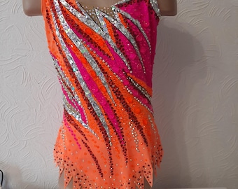 May include: A vibrant orange and pink leotard with silver accents and sparkling embellishments. The sleeveless garment features a diagonal design with a gradient effect, perfect for gymnastics or dance performances.
