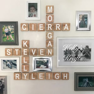 May include: A white wall with a wooden block letter crossword puzzle spelling out the names "Morgan", "Steven", "Kiera", and "Ryleigh". There are also several framed photos of children and families.