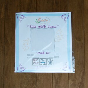 May include: A white water-soluble canvas for embroidery, packaged in a clear plastic bag. The canvas is labeled "Water soluble Canvas" and "count 14".