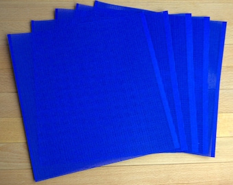 May include: A set of five square, royal blue plastic mesh sheets arranged in a slightly fanned, overlapping stack. Each sheet features a uniform, fine grid pattern throughout its surface, creating a semi-transparent appearance across the stack.