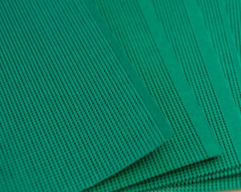 May include: A stack of rectangular sheets of paper in a vibrant emerald green colour. Each sheet features a fine, vertical ribbed texture that runs parallel along the length of the paper, creating a consistent linear pattern across the entire surface.