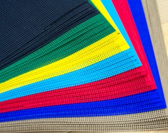 May include: A collection of rectangular plastic mesh sheets arranged in a fan pattern, featuring a variety of vibrant colours including dark blue, green, yellow, light blue, red, and beige, each with a uniform grid of small circular holes.