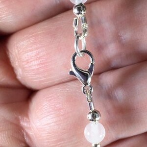 May include: A black and white beaded bracelet with a silver clasp. The bracelet features black faceted beads and white round beads.