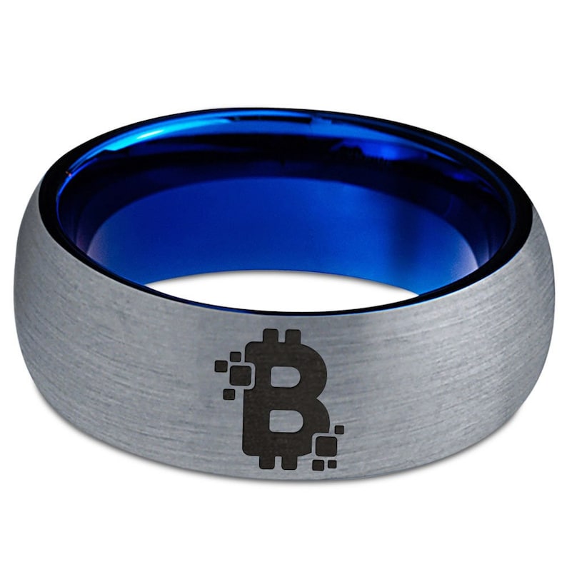 Op de afbeelding: Een zilveren ring van wolfraamcarbide met een blauwe binnenband en een zwart Bitcoin-symbool gegraveerd aan de buitenkant.