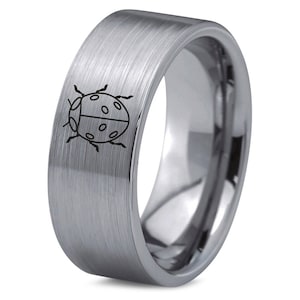 May include: A brushed silver ring with a black outline of a ladybug engraved on the band.