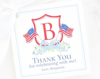 May include: A white thank you tag with a red, white, and blue shield with the letter "B" in the center. The shield is flanked by two American flags. The text "Thank You for celebrating with me! Love, Benjamin" is printed below the shield.