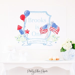 May include: A watercolor illustration of a blue and white shield with the text "Brooks is One All American Boy". The shield is decorated with red, white, and blue stars, balloons, and flags.