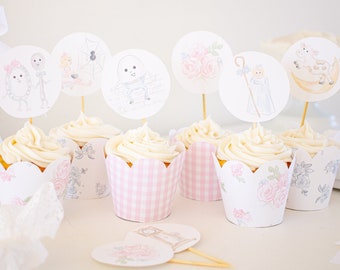 Könnte beinhalten: Cupcakes mit weißem Zuckerguss und dekorativen Toppern mit skurrilen Illustrationen. Die Cupcake-Förmchen haben Blumen- und Vichy-Muster in Rosa und Weiß. Die Topper zeigen verschiedene Charaktere und Designs, ideal für eine Party.