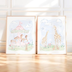 May include: Two framed watercolour prints. One shows a carousel with horses, the other depicts giraffes. Both have a soft colour palette of pink, blue, and green. The carousel print includes a rabbit, and the giraffe print includes two rabbits.