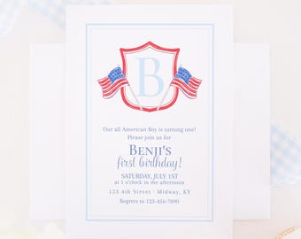 May include: A white invitation card with a light blue border. The card features a shield with the letter "B" and two American flags. Text on the card reads "Our all American Boy is turning one!" and "BENJI'S first birthday!"