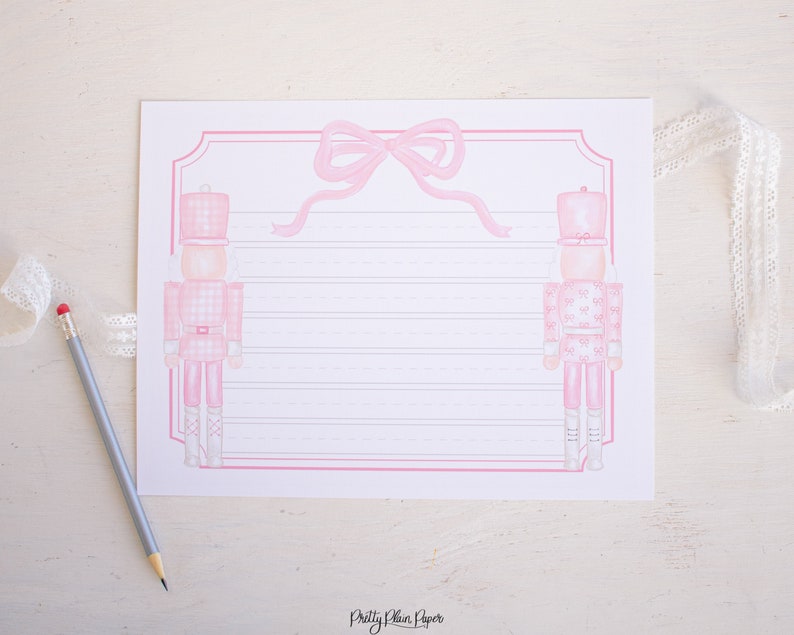 May include: Printable pink and white lined paper with a pink bow and two pink nutcracker illustrations. The paper has the text "Pretty Plain Paper" at the bottom.