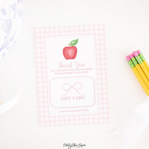 May include: Pink and white gingham gift card with a red apple and a white ribbon. The text on the card reads "Thank You for making the first day so sweet! Dinner tonight is our treat!" and "GIFT CARD". The card also includes the text "Love, the Anderson Family".