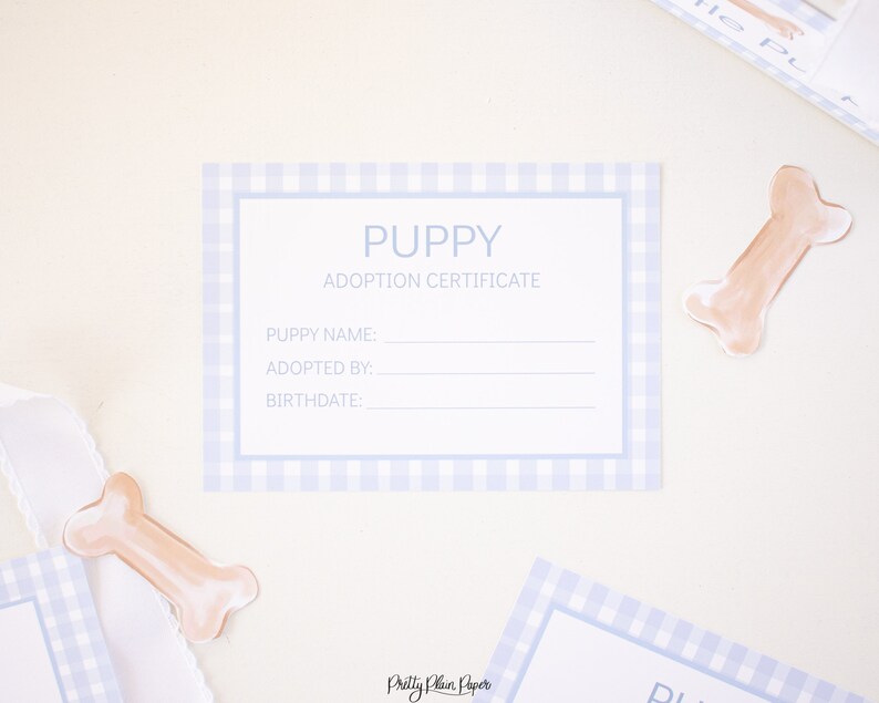 May include: A blue and white gingham puppy adoption certificate with the text "PUPPY ADOPTION CERTIFICATE" and blank lines for the puppy's name, adopted by, and birthdate.