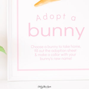 May include: A white sign with pink text that says "Adopt a bunny". The sign also includes instructions to choose a bunny, fill out an adoption sheet, and make a collar with the bunny's new name.