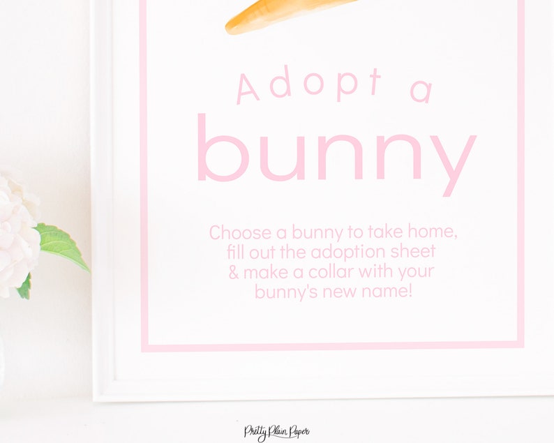 May include: A white sign with pink text that says "Adopt a bunny". The sign also includes instructions to choose a bunny, fill out an adoption sheet, and make a collar with the bunny's new name.