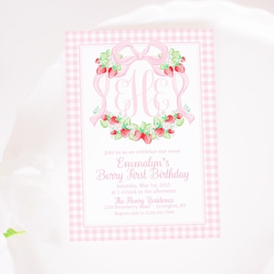 Puede incluir: Una invitación de patrón de cuadros vichy rosa y blanco con un lazo rosa y una corona de fresas. El texto dice "Join us as we celebrate our sweet Emmalyn's Berry First Birthday Saturday, May 1st, 2025 at 1 o'clock in the afternoon. The Henry Residence 1234 Strawberry Road Lexington, KY Regrets only to (123) 456-7890"