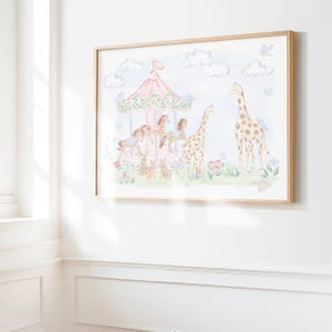 May include: A framed watercolour print depicting a carousel with horses and giraffes. The carousel has a pink roof and is set in a scene with clouds and flowers. The frame is made of light-coloured wood.