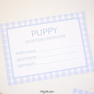 May include: A blue and white gingham puppy adoption certificate with the text "Puppy Adoption Certificate" and blank lines for the puppy's name, adopted by, and birthdate.