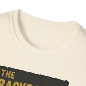 Backrooms horror graphic tee with liminal space hallway art, shadow figure, and vintage grain effect; printed on high-quality black cotton T-shirt for creepypasta and analog horror fans.