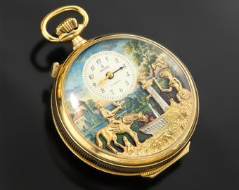 Puede incluir: Un reloj de bolsillo dorado con una escena pintada detallada en la esfera. El reloj presenta una esfera blanca con números negros y agujas doradas. La escena representa figuras, un caballo y un edificio. El reloj tiene una corona dorada y un bisel texturizado.