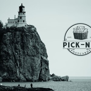 May include: Black and white image of a lighthouse perched atop a rocky cliff overlooking a body of water. The image includes a logo that says "PICK-NIK POSTCARDS" with a basket illustration.