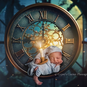 May include: A baby sleeping on a large antique clock face with Roman numerals. The baby is holding a lit candle and is wearing a blue and white striped onesie. The clock face is surrounded by a gold frame and has a blue background.