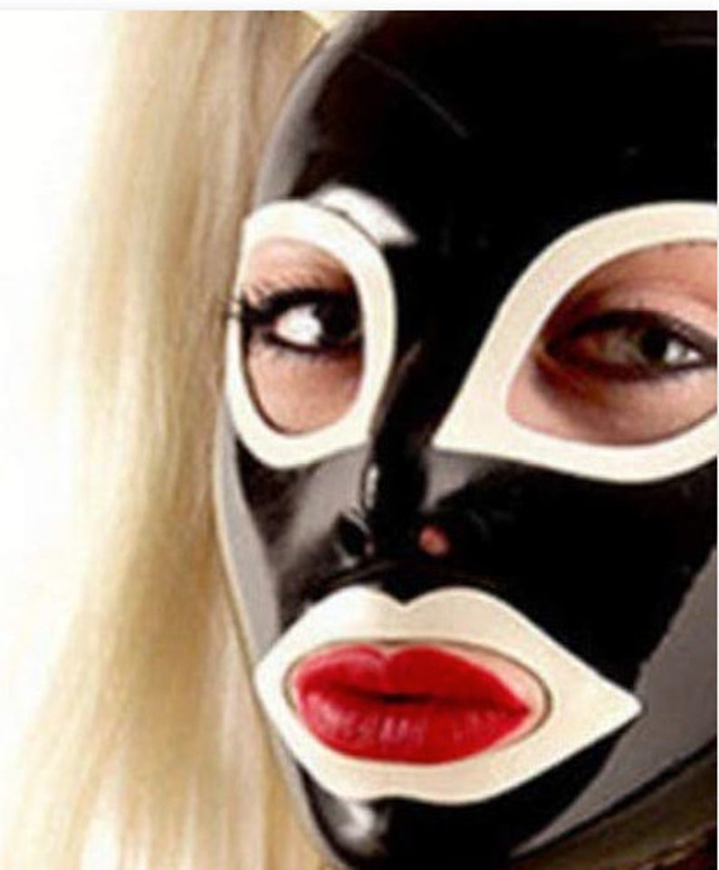 Puede incluir: Una m&aacute;scara de l&aacute;tex negra con detalles blancos alrededor de los ojos y la boca. La m&aacute;scara tiene una boca pintada de rojo.