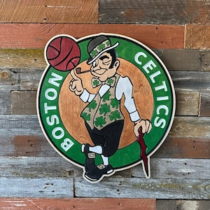Op de afbeelding: Een groen en bruin houten bord met een cartoon-kabouter die een basketbal en een pijp vasthoudt. Het bord heeft de tekst "Boston Celtics" in witte letters.