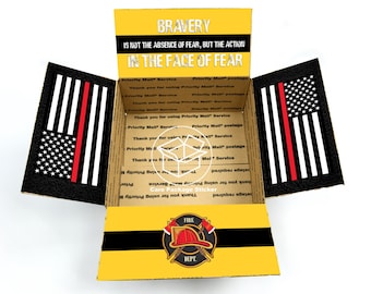 May include: A yellow cardboard box with a red, white, and blue American flag with a red stripe on the side. The box is open and the inside is lined with a black and white pattern. The box has a sticker on the front that says "BRAVERY IS NOT THE ABSENCE OF FEAR, BUT THE ACTION IN THE FACE OF FEAR". The sticker also has a firefighter helmet and crossed axes with the words "FIRE DEPT."