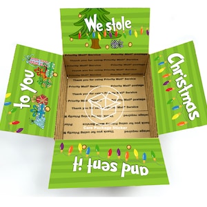 May include: A green and white cardboard box with a Christmas tree design and the text "We stole Christmas and sent it to you!"  The box is decorated with colorful lights and presents.