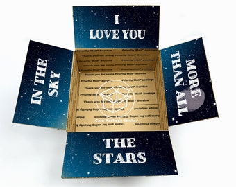 May include: A cardboard box with a starry night sky design. The box is open and the inside reads "I love you more than all the stars".