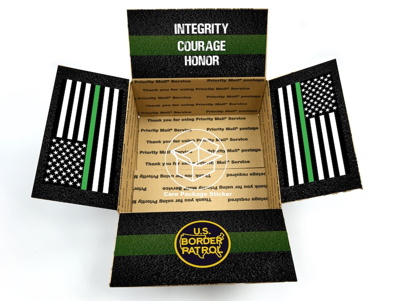 May include: An open cardboard box with a black and green American flag design. The box has the words "Integrity, Courage, Honor" printed on the top flap. The box also has a sticker with the words "U.S. Border Patrol" and a badge design.