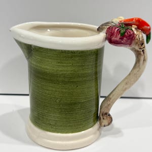 May include: A white ceramic mug with a black handle and the text "But First, Coffee" in a black, bold font. The mug is on a white surface.