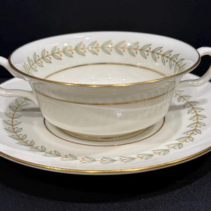 May include: A set of three ceramic mugs with a speckled, matte finish. The mugs are in shades of cream, light gray, and dark gray. Each mug has a simple, minimalist design and a rounded handle.