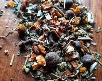 May include: A mix of dried herbs, spices, and fruit peels for making herbal tea. The mix includes dried orange peel, ginger, cloves, and other ingredients.