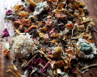 Peut inclure: Un mélange d'herbes séchées, de fleurs et de morceaux de fruits pour le thé. Le mélange comprend des fleurs de camomille, des pétales de rose, des morceaux de pomme séchés et d'autres plantes.