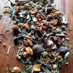 Op de afbeelding: Een mix van gedroogde kruiden, vruchten en specerijen om thee te maken. De mix bevat gedroogde sinaasappelschil, citroengras, kamillebloemen en kruidnagel.