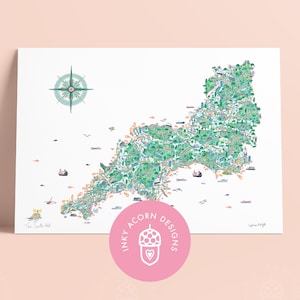 May include: A detailed map print of a landmass, filled with green and blue illustrations. A compass rose is in the upper left corner. The print has a pink circular logo with the text "Inky Acorn Designs".