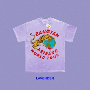 May include: Lavender t-shirt with a graphic featuring a tiger wrapped around a globe, with the words "BANGTAN ARIRANG WORLD TOUR" in red. The tiger is yellow and black. A tag hangs from the collar.