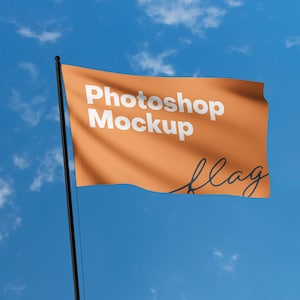 Pode incluir: Uma bandeira laranja com o texto "Photoshop Mockup" e a palavra "flag" escrita em itálico. A bandeira está a ondular ao vento contra um céu azul com nuvens brancas.