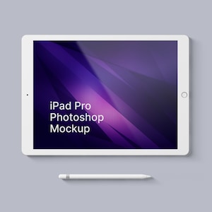 May include: White iPad Pro tablet with a purple and black abstract design on the screen. The text "iPad Pro Photoshop Mockup" is displayed on the screen. A white Apple Pencil is lying below the tablet.