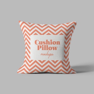 May include: A white cushion pillow with a red and white chevron pattern. The pillow has a white label with the text "Cushion Pillow Mockups" in a red font.